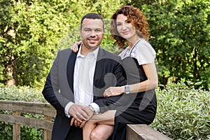 Portrait of a couple in love. A Middle Eastern man in a business suit with his curly-haired wife in a black dress