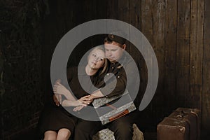 Portrait couple in military uniforms from the second world war young woman and man with accordion sit in embrace