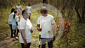 Portrait of couple volunteering to plant trees and collect trash from the woods