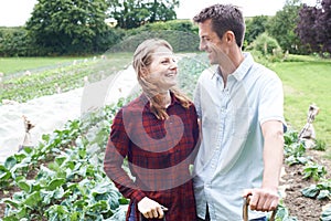 Portrait Of Couple Working In Organic Farm Field