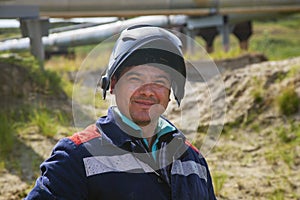 Portrait of courageous welding man on gas pipeline with a smile on his face