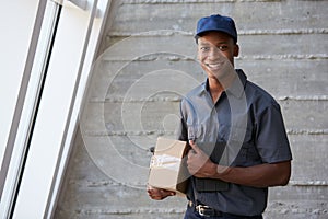 Portrait Of Courier Collecting Package From Office