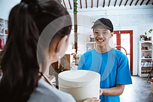 portrait courier smiling bring the package for young female shopkeeper