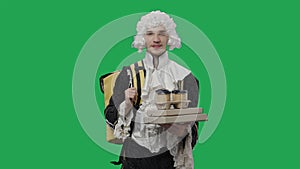 Portrait of courtier gentleman in black historical vintage suit and white wig, delivering food and drinks. Young man