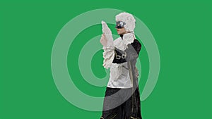Portrait of courtier gentleman in black historical vintage suit, white wig and the mask bowing and curtsy. Young man