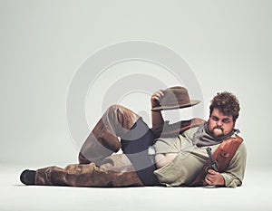 Portrait, cowboy and criminal with gun in studio mockup, outlaw and wild west character with pistol. Overweight texas