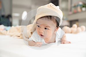 Portrait of a crawling baby on the bed in her room, Adorable baby boy in white sunny bedroom, Newborn child relaxing in bed