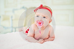 Portrait of a crawling baby on a bed in his room. The concept of a happy child