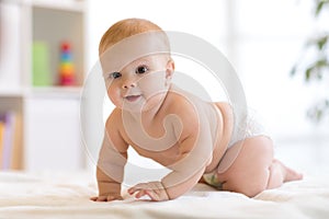 Portrait of a crawling baby on the bed in nursery room