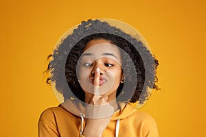 Portrait of crazy african american young woman with beautiful smile dressed in casual clothes over yellow background.