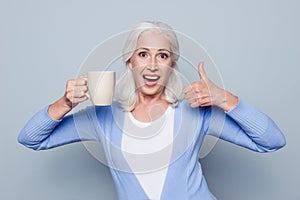 Portrait of crazy coffee lover. Joyful happy excited grandmother