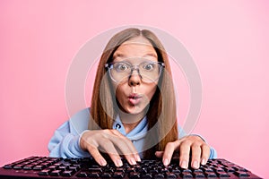 Portrait of crazy impressed person typing keyboard pouted lips staring isolated on pink color background