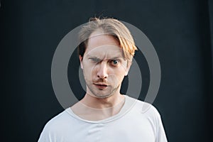 Portrait of crazy man at dark wall