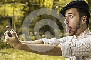 Portrait of a crazy young man with cap taking a selfie