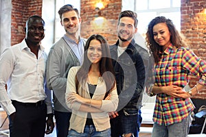 Portrait of creative business team standing together and laughing. Multiracial business people together at startup.