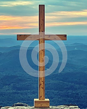 A portrait of a cross with a sunrise in the background. photo