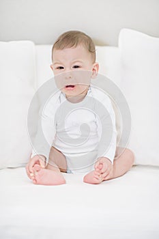 Portrait of crying baby boy in white. Little Angel