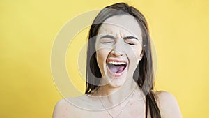 Portrait of the crying girl on yellow background in 4K
