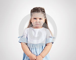 Portrait of crying little girl on grey background