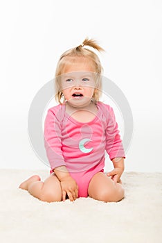 portrait of crying toddler girl in bodysuit looking away