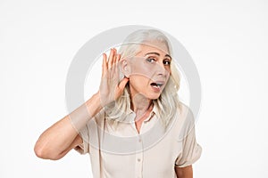 Portrait of a curious mature woman trying to hear something