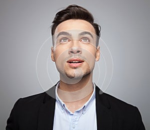 Portrait of curious shocked businessman looking up