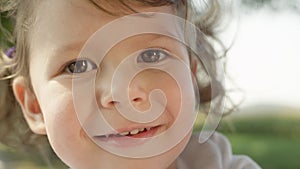 PORTRAIT: Curious small Caucasian girl looks around the sunny summer nature.