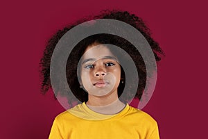 Portrait of curly black child over colorful background