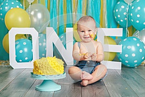 Caucasian baby boy celebrating his first birthday. Cake smash