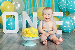 Caucasian baby boy celebrating his first birthday. Cake smash