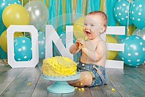 Caucasian baby boy celebrating his first birthday. Cake smash