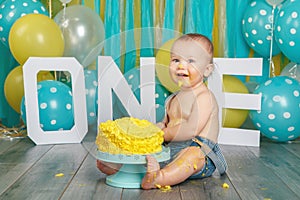 Caucasian baby boy celebrating his first birthday. Cake smash