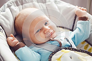 Portrait of cute adorable funny white Caucasian blond little baby boy newborn with blue grey eyes in blue clothes