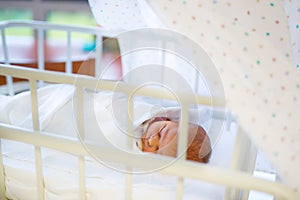 Portrait of cute adorable newborn baby girl in birth hospital.