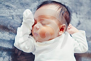 Portrait of cute adorable sleeping Asian Chinese mixed race newborn baby girl boy lying on bed in bedroom.