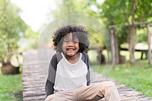 Portrait of a cute African american little boy smiling at nature park