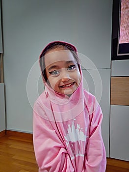 Portrait of a cute Asian little girl with funny eyeliner make up on her face smiling