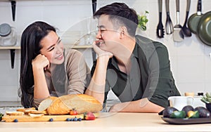 Portrait cute Asian young adult couple lover helping together, cooking in cozy home kitchen in morning, preparing breakfast meal,