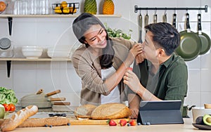 Portrait cute Asian young adult couple lover helping together, cooking in cozy home kitchen in morning, preparing breakfast meal,