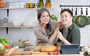 Portrait cute Asian young adult couple lover helping together, cooking in cozy home kitchen in morning, preparing breakfast meal,