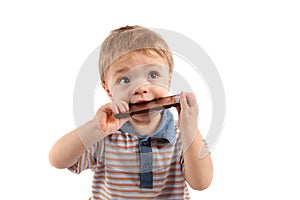 Portrait of a cute baby boy eating chocolate.