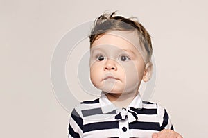 Portrait of a cute baby boy looking away surprised with his big eyes.