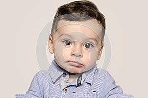 Portrait of a cute baby boy looking at camera bored.