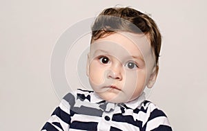 Portrait of a cute baby boy looking at camera with his big eyes.