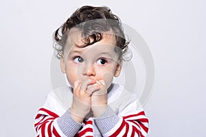 Portrait of a cute baby boy looking up surprised.