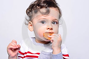 Portrait of a cute baby eating a biscuit.