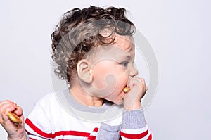 Portrait of a cute baby eating a biscuit.