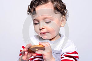 Portrait of a cute baby eating a biscuit.