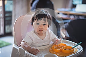 Portrait of cute baby eating dirty on the table