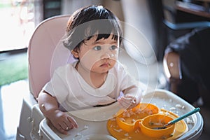 Portrait of cute baby eating dirty on the table